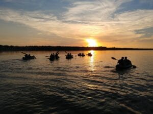 people kayaking in belgrade at sunset
