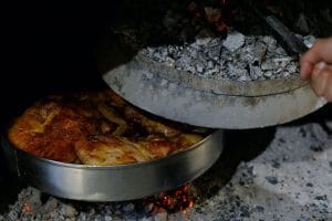 Serbian way of slowly cooking meat at open fire under a metal lid called Sač